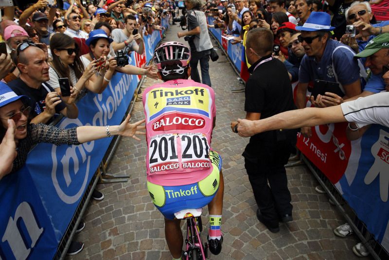 Alberto Contador rides to the sign on through the fans