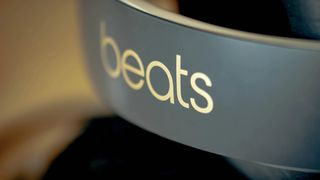 gold Beats logo on a pair grey of headphones