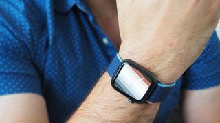Apple Watch SE on a wrist, the person is wearing a blue shirt