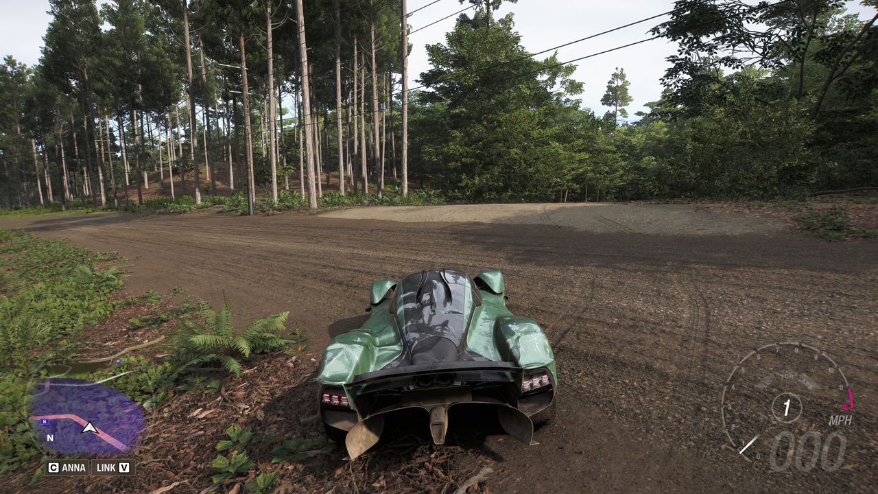 Forza Horizon 6 Barn Finds: A player parked on a dirt road, looking down a narrower path which leads to a barn in the woods.