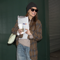 katie holmes wears a flannel jacket and autry sneakers with jeans