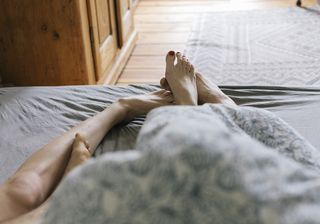Male escort on a job: a shot of a couples feet in bed post-sex