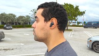Side profile of reviewer wearing JBL Tour Pro 2 wireless earbuds