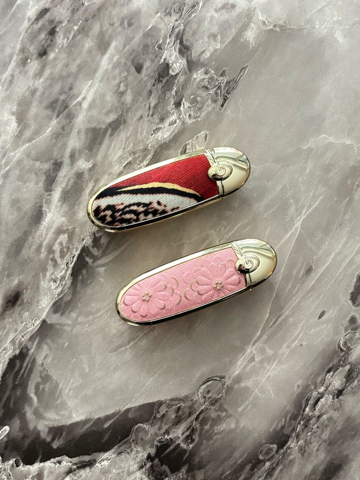 Two Guerlain Rouge G lipstick cases on a marble table