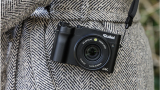 Close up of the Rollei Powerflex V8 compact camera, slung over a person's shoulder and resting by their side