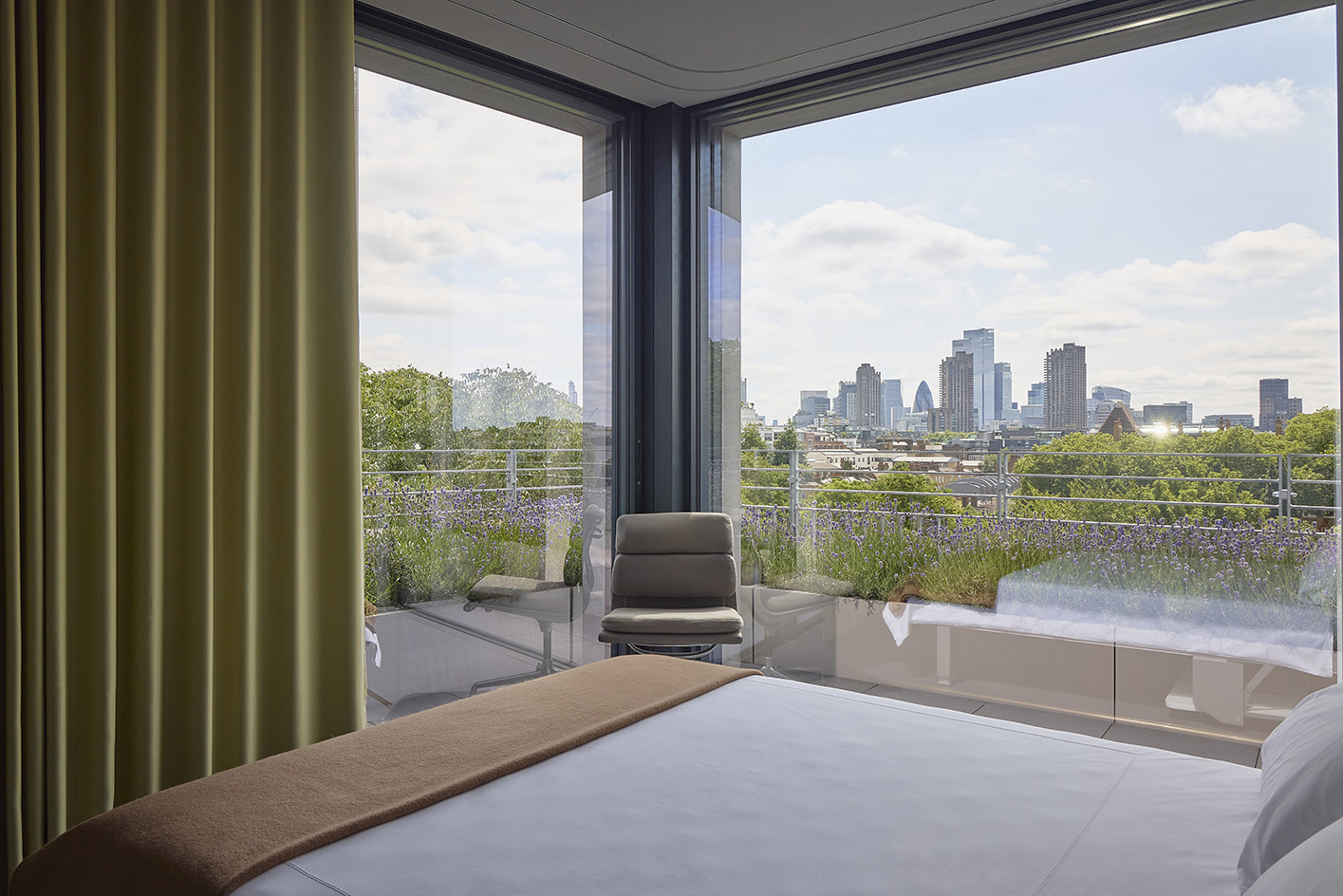 Clerkenwell Rooftop apartment in London, showing minimalist concrete and large openings with terrace and views out to urban views with green