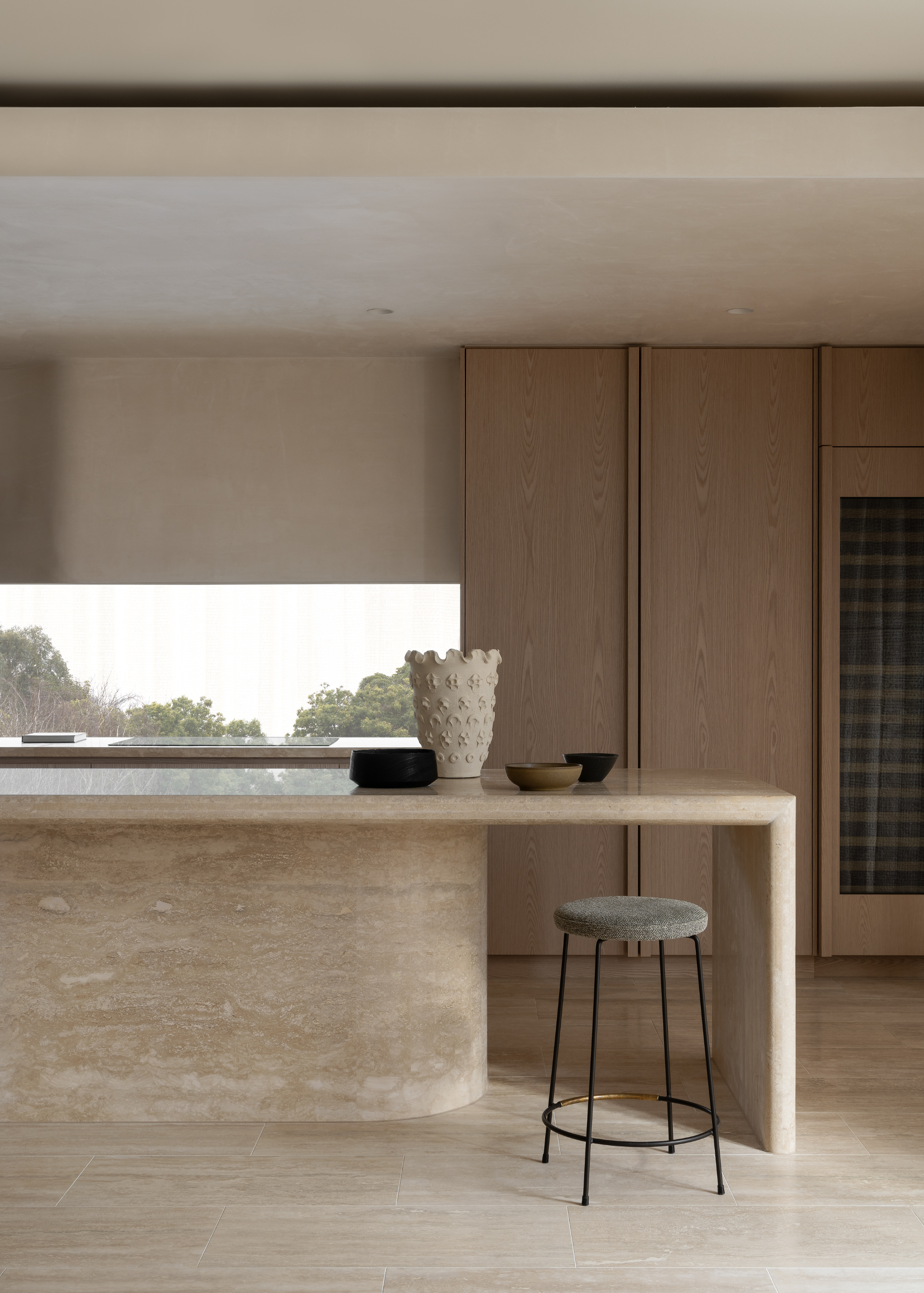 a travertine kitchen island with matching floors and cabinets