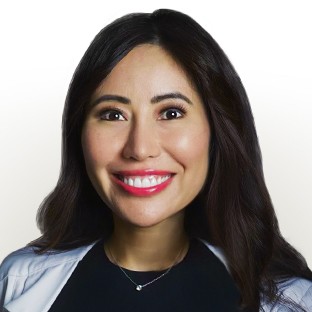 A woman, Dr. Rachel Reyes-Bergano, wearing a medical coat with dark hair and pink lipstick.