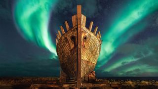 An old wooden Viking ship takes center stage with the aurora borealis shining above.