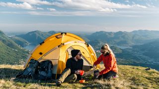 Couple wild camping on hilltop