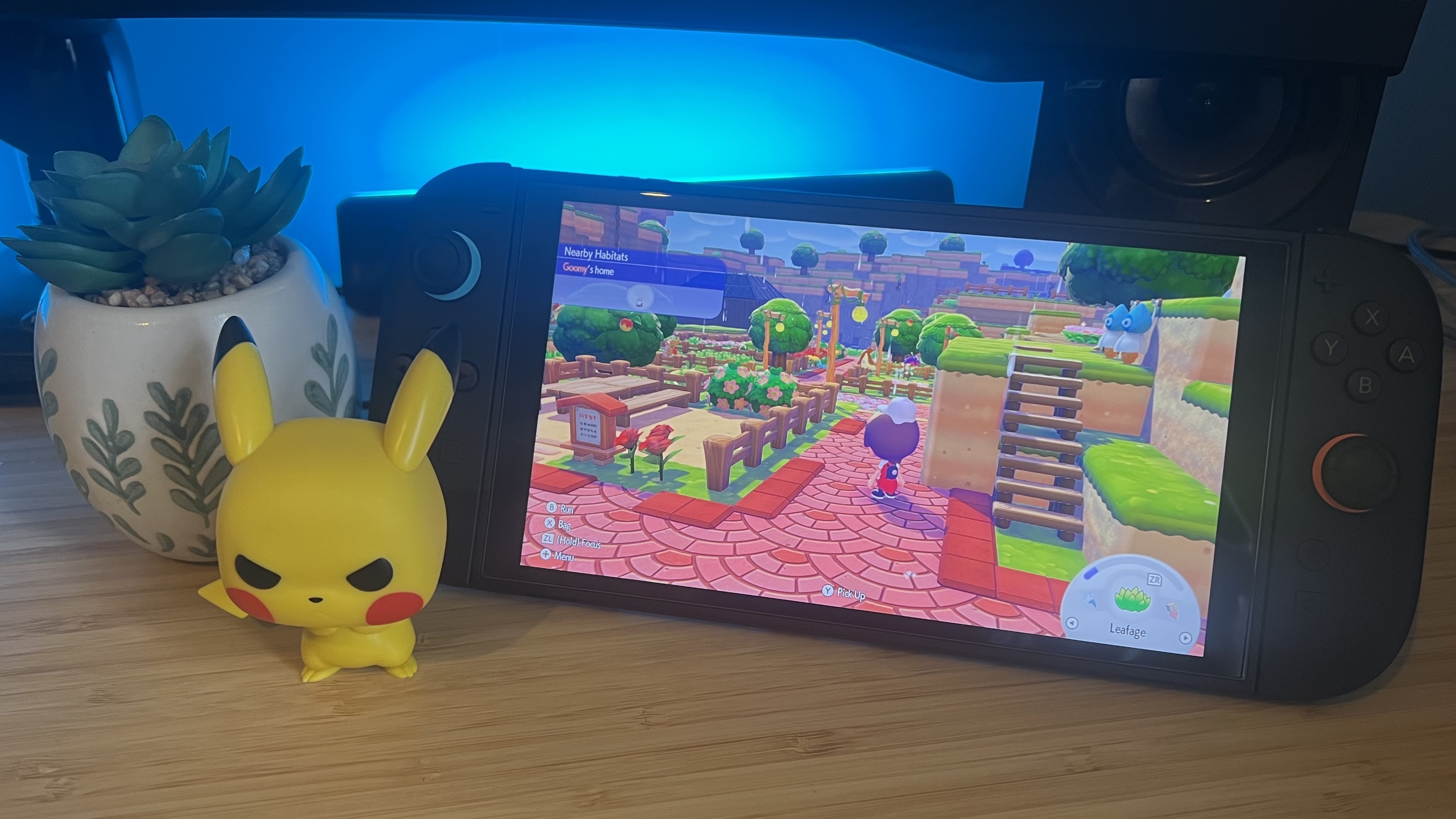 Nintendo Switch 2 running Pokemon Pokopia with a Pikachu Pop Vinyl on a wooden desk