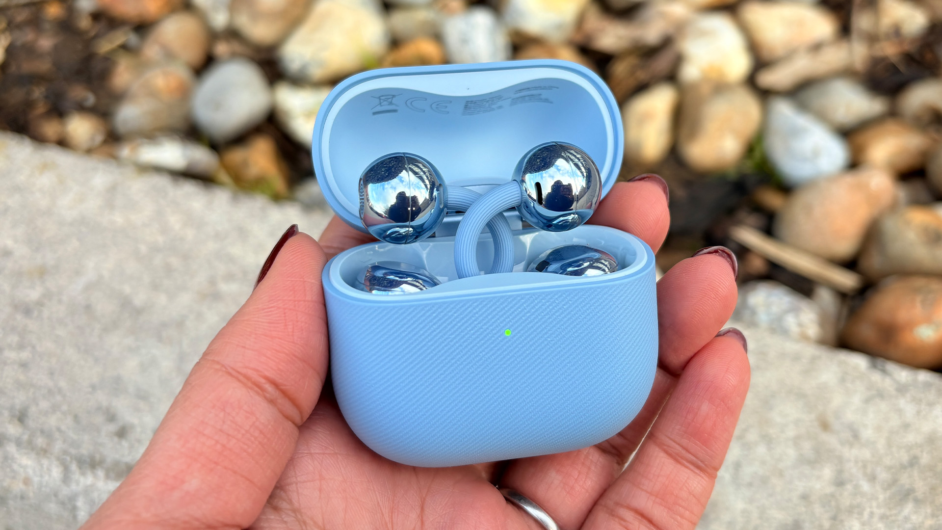 Huawei FreeClip 2 wireless earbuds in open case held in hand