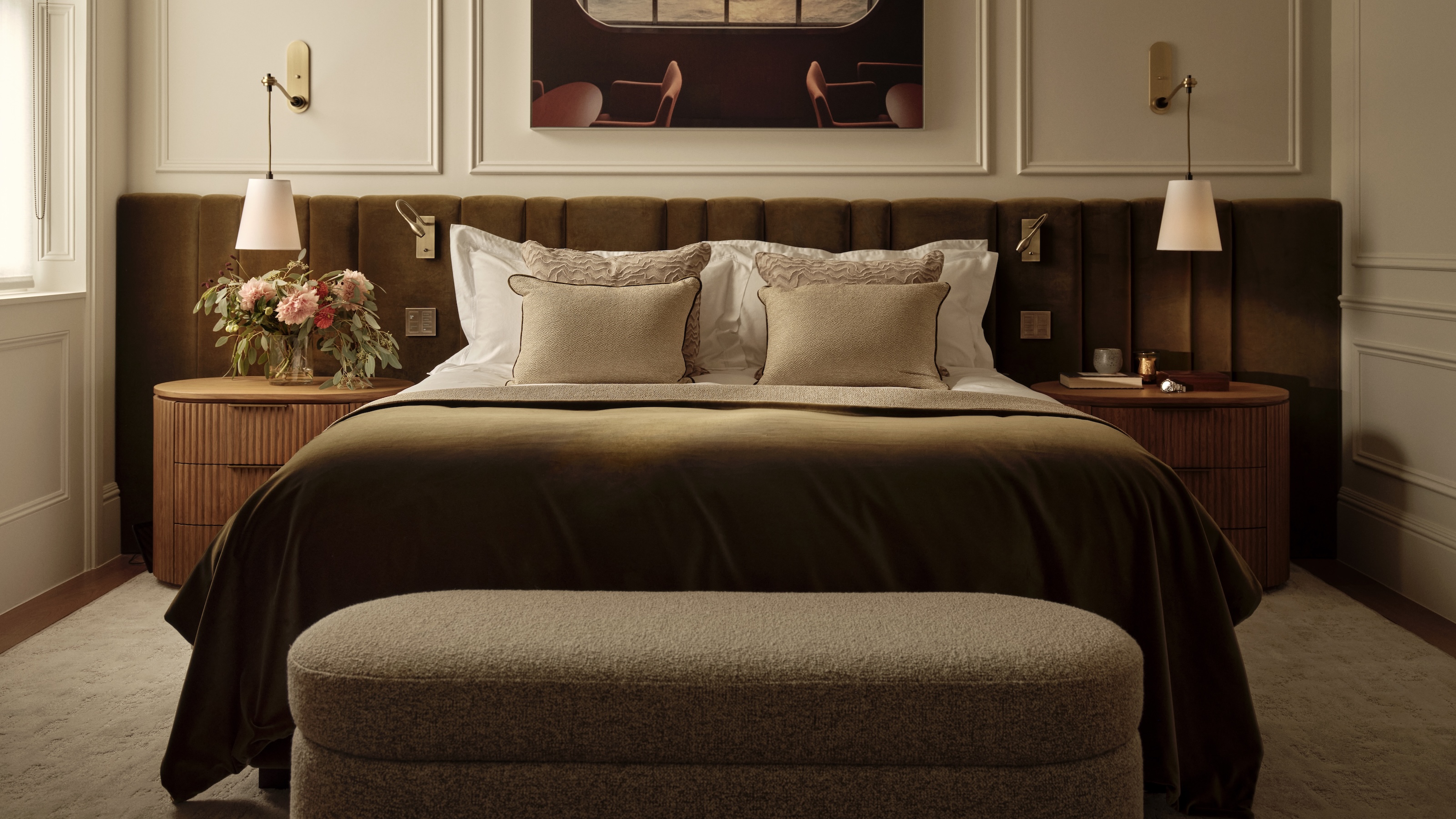 A contemporary bedroom with symmetrical layout, velvet headboard and matching nightstands