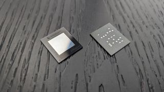 A Snapdragon X microchip on a black wooden surface.