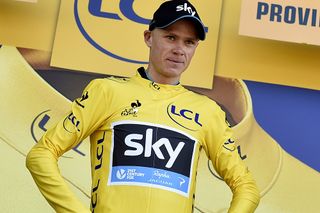 Chris Froome (Team Sky) puts on the yellow leader's jersey