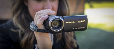 The Panasonic HC-V180 camcorder being held by a young woman