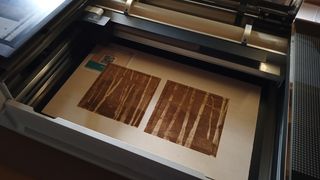 The Glowforge Pro review, two engraved paintings sit in a laser cutter machine