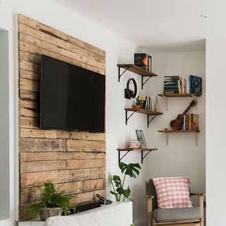 living room with walled tv and armchairs