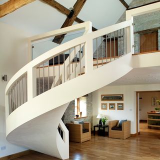 living room with curved staircase and wooden flooring
