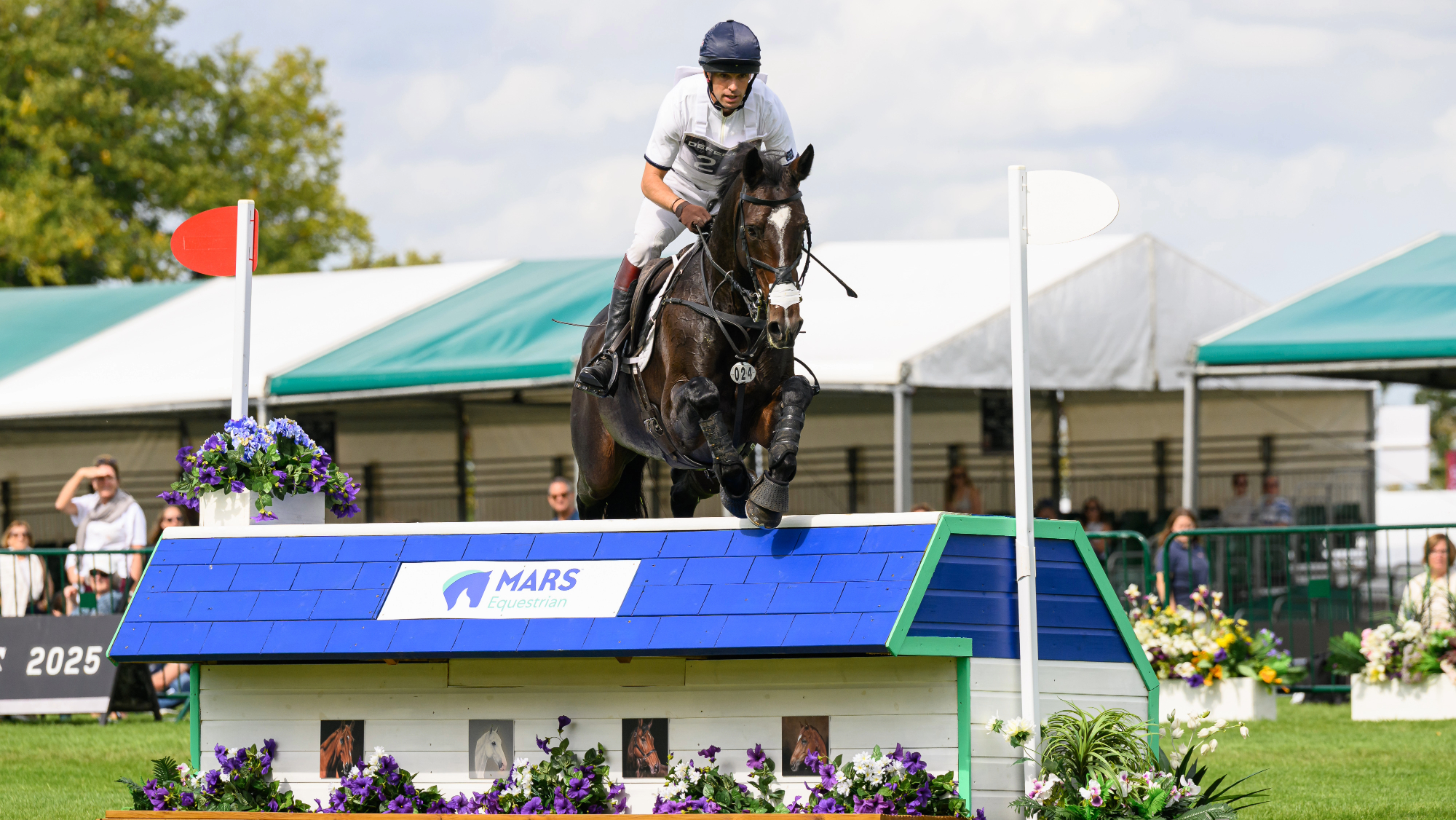 Harry Meade jumping a Mars branded fence on Cavalier Crystal in the main arena at the Defender Burghley Horse Trials