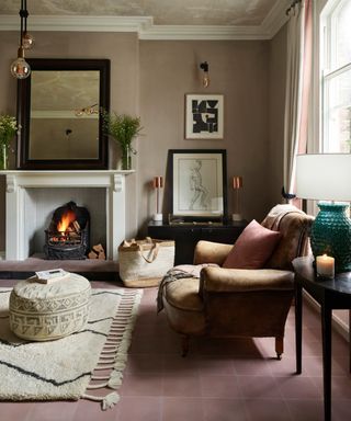 Soho House fireplace with grey inset tiles and pink tiled flooring, a blush pink wall and beige and black furniture