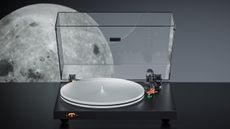The Fosi Audio Luna 3 on a black surface with an image of the Moon behind it