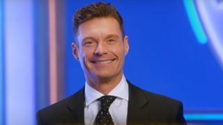 Ryan Seacrest smiles in an ad for the upcoming 2024 season of Wheel of Fortune.