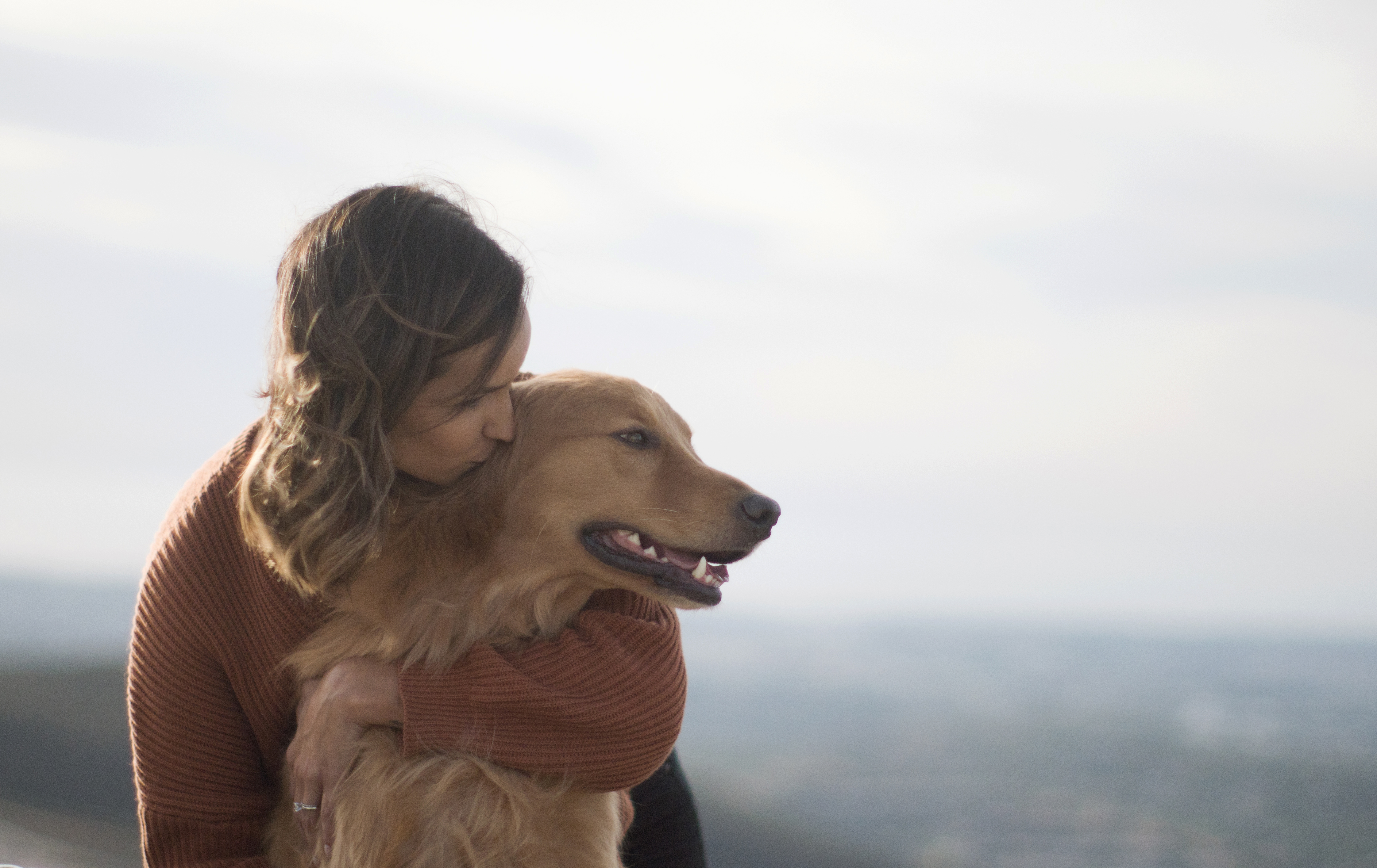 Woman cuddling golden retriever