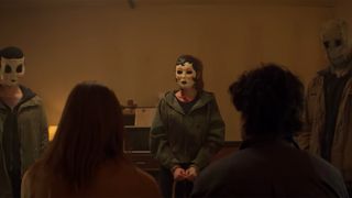 The Strangers standing in a line confronting their captives