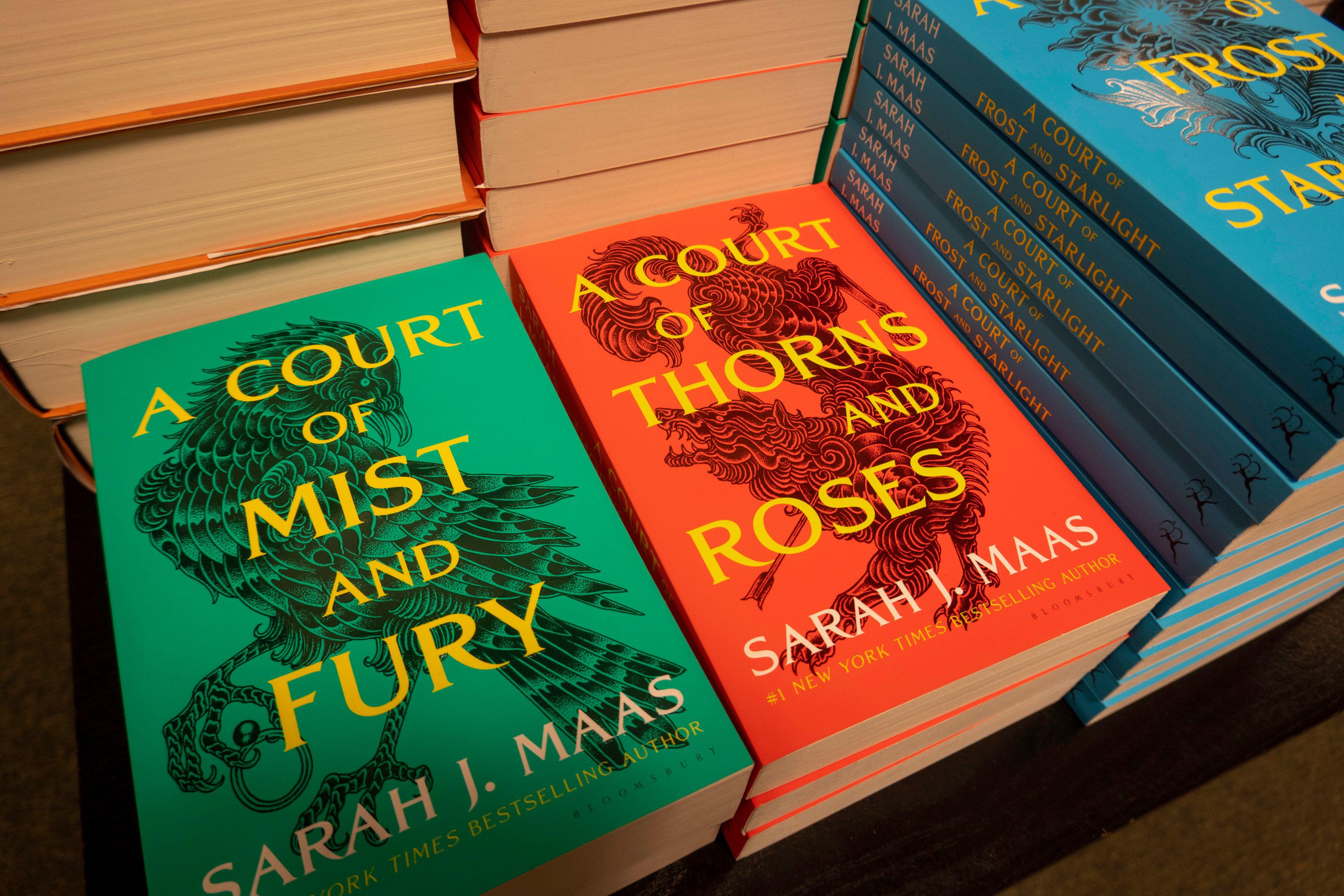 Stacked books from the 'A Court of Thorns and Roses' series at a book store
