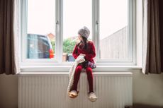 girl looking through the window in her new home