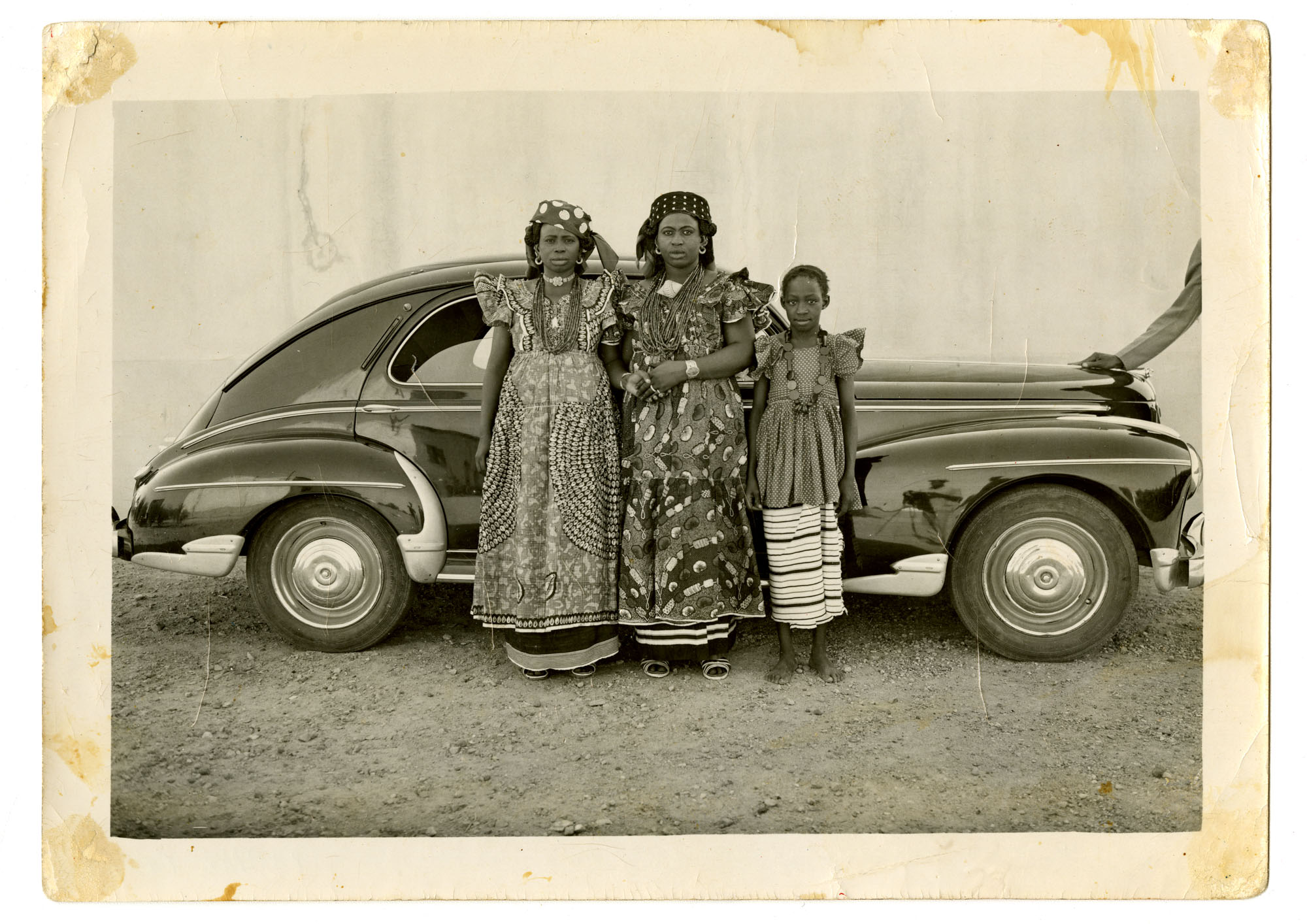 black and white portrait by photographer Seydou Keïta of family beside car