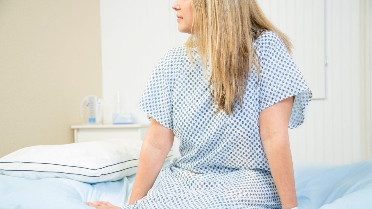 Woman in hospital gown preparing for cervical screening