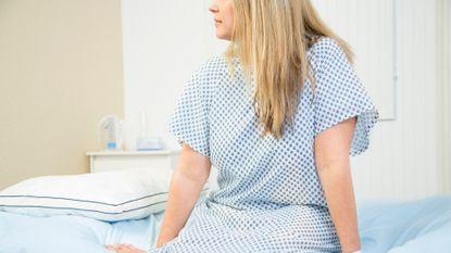 Woman in hospital gown preparing for cervical screening