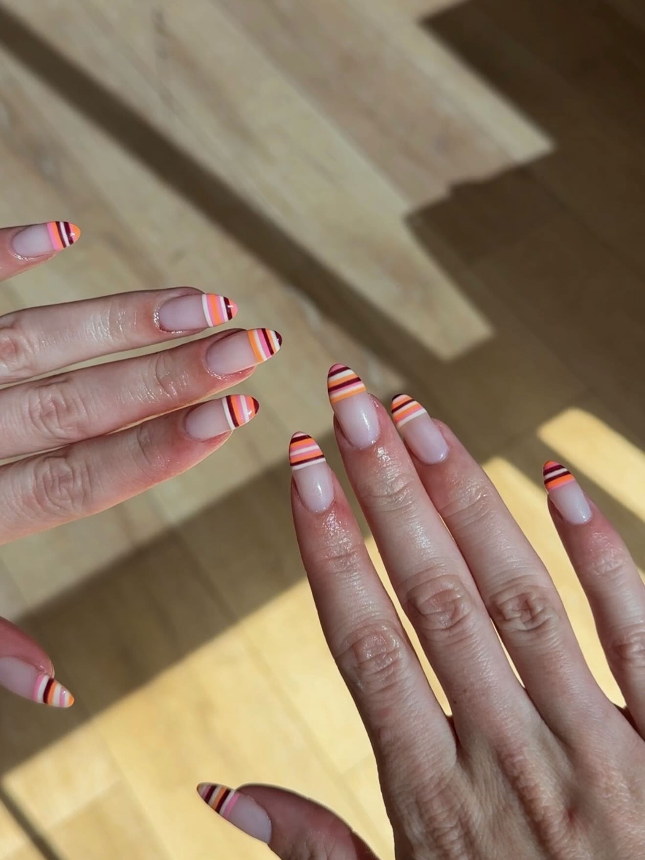 Orange and brown striped French tips.