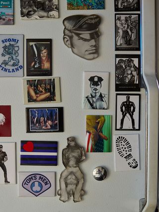 Close up shot of male erotic fridge magnets on a white fridge door, white door handle to the right
