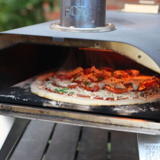 Pizza cooking in a Drew & Cole wood fired pizza oven