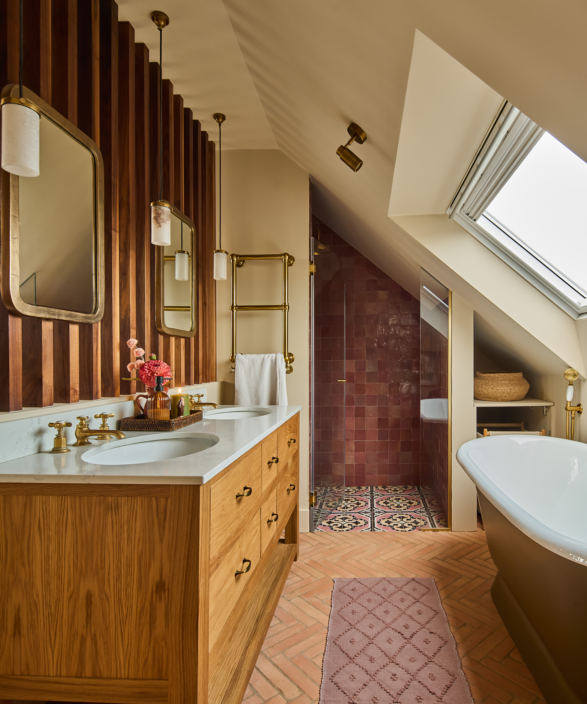 bathroom with wood vanity, herringbone tiled floor and shower niche with zellige tiles