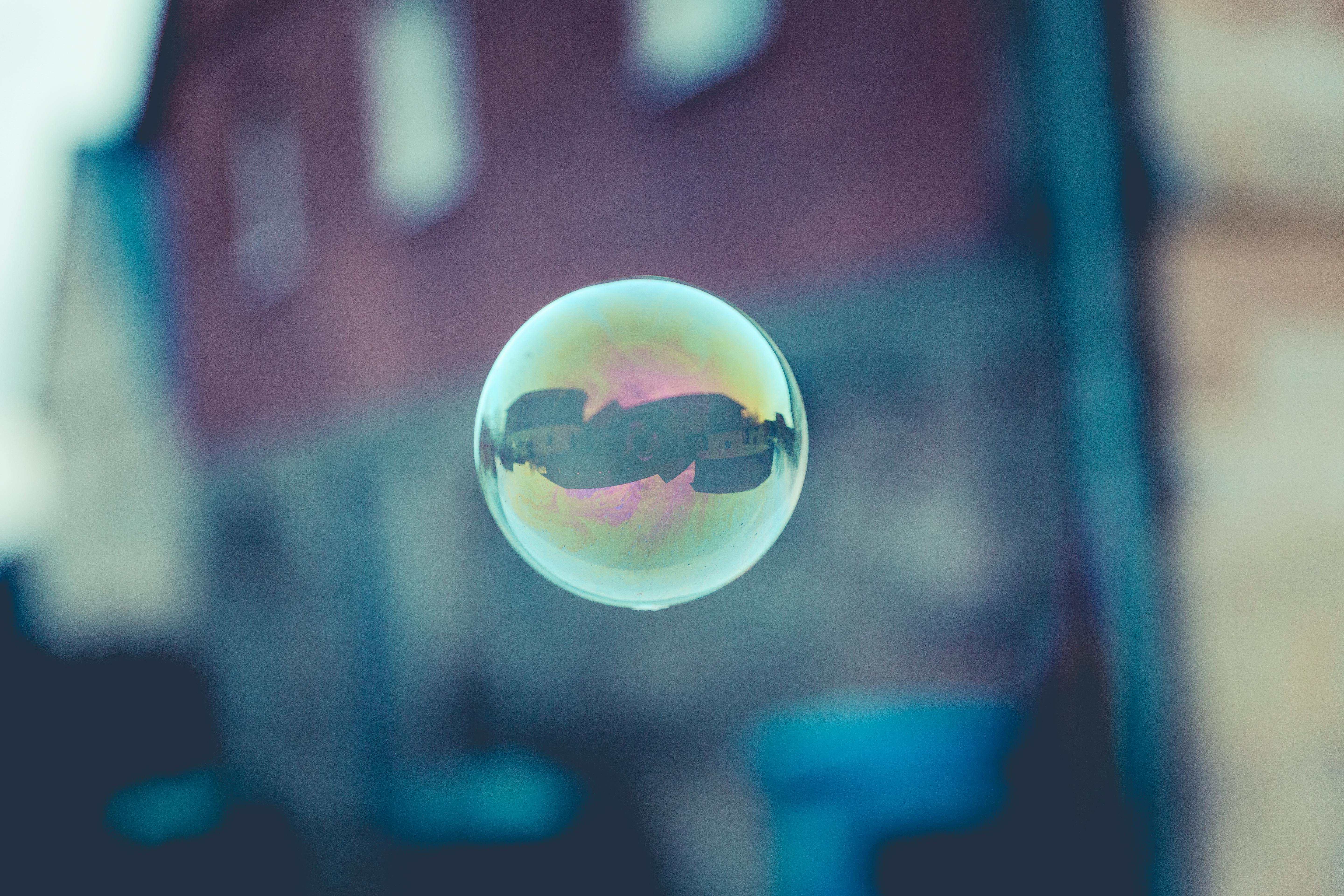 A soap bubble floats against a blurred background