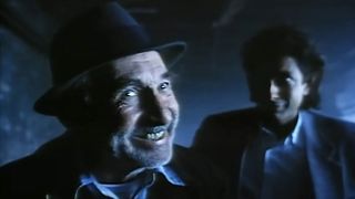 Ed McNamara's creepy old man smiling at the camera while Jeff Goldblum's city slicker stands near in "The Town Where No One Got Off" In The Ray Bradbury Theater.