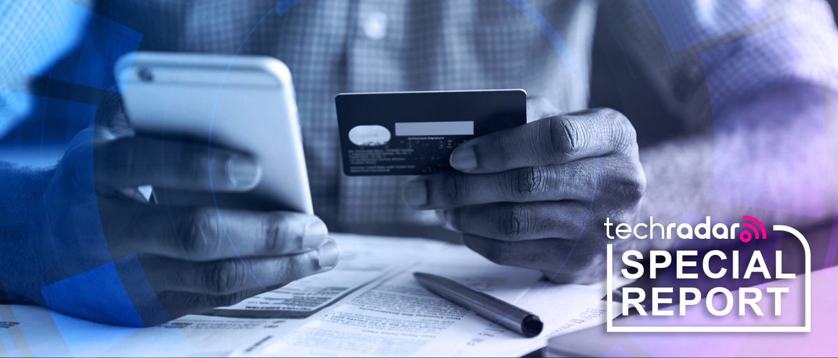 A man&#039;s hand holding a credit card next to a mobile phone