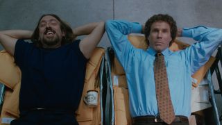 Mailroom Guy (Mark Acheson) and Buddy (Will Ferrell) lying on mail bins in the mailroom in the movie Elf.