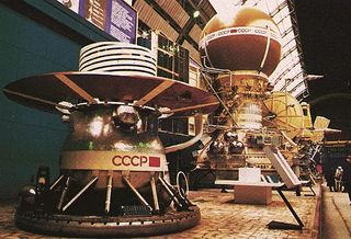 A mockup of the Venera 13 spacecraft is displayed at the Cosmos Pavilion of the Exhibition of the Achievements of the National Economy in Moscow, Russia. The lander module in the foreground would sit inside the brown sphere atop the Venera spacecraft (background).