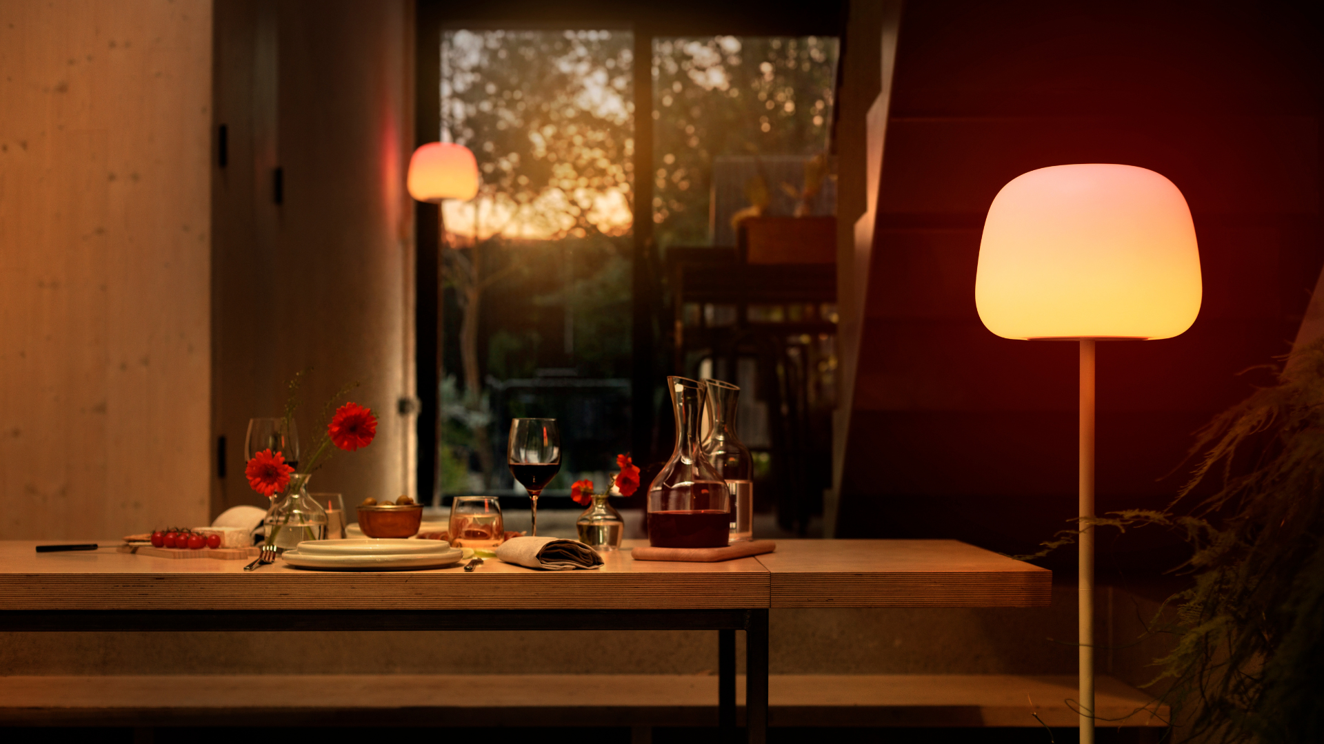 A tall floor lamp emitting a warm light by a dining room