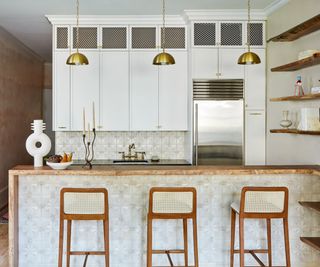 gold kitchen pendant lights in a wood and white kithen