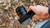 Sigma FP2 with a 50mm lens being held one-handed outdoors.