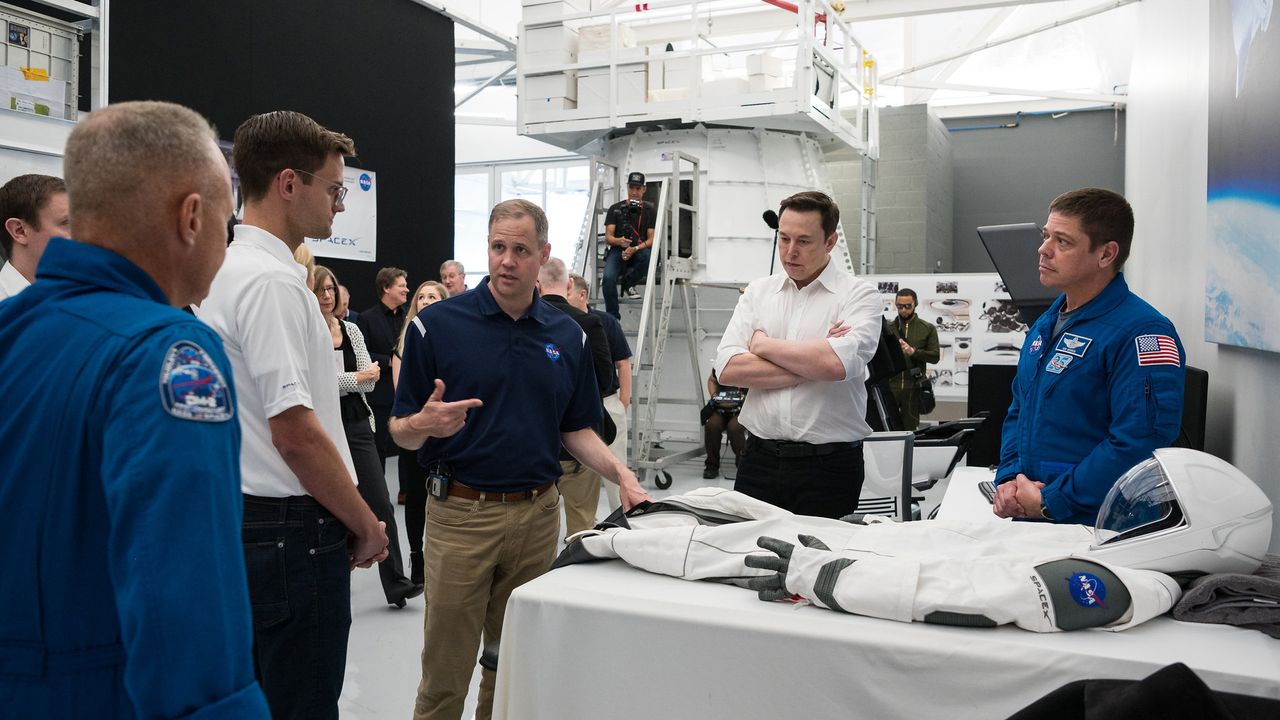 SpaceX Chief Engineer Elon Musk, second from right, and NASA astronaut Bob Behnken, right, look on as NASA Administrator Jim Bridenstine, third from left, speaks to NASA astronaut Doug Hurley, left, as they look at an identical version of the SpaceX spacesuit that he will wear for the Demo-2 mission during a visit to SpaceX Headquarters, Thursday, Oct. 10, 2019 in Hawthorne, CA. Behnken and Hurley are assigned to fly onboard Crew Dragon for the Demo-2 mission.