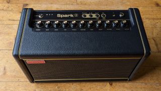 A Positive Grid Spark 2 desktop guitar amp on a wooden floor