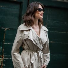 fashion week attendee wearing sunglasses and trench coat
