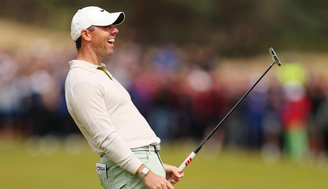 Rory McIlroy laughs whilst holding his putter